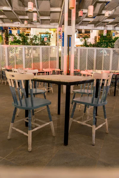 Уличный интерьер кафе, открытые деревянные столы и стулья — стоковое фото