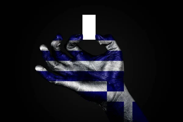 Mano con una bandera pintada Grecia sosteniendo una pequeña hoja blanca con espacio para una inscripción, se burlan de —  Fotos de Stock