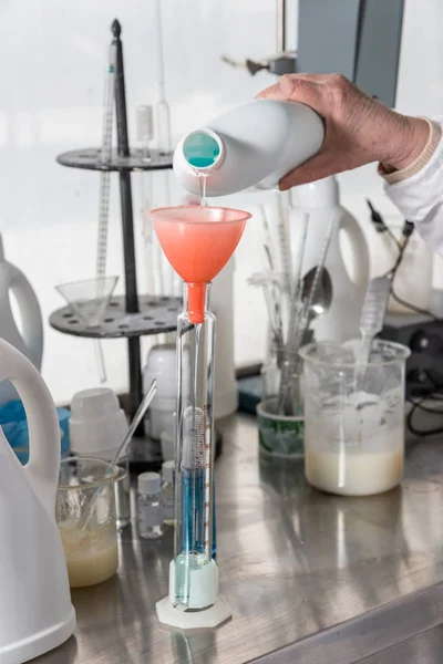 Chemistry and medicine, hand pours some liquid into the flask — Stock Photo, Image