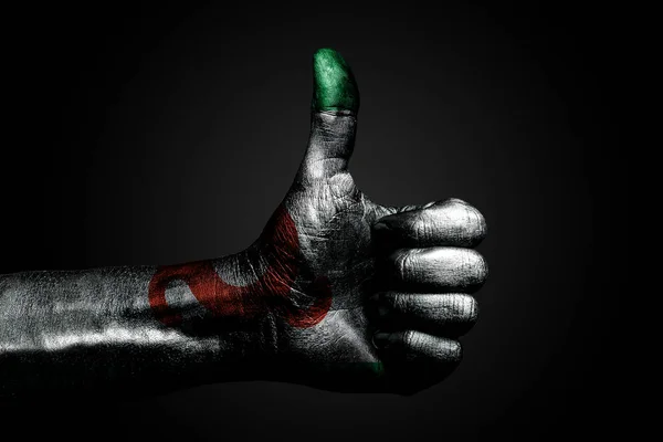 一只手拿着一面画着的印古什国旗，上面写着一个手指上的标志，象征着成功，准备，在黑暗的背景上完成的任务. — 图库照片