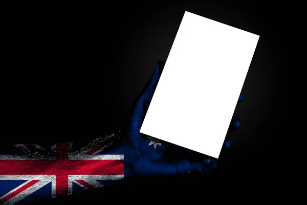 Mano con bandera pintada Australia sosteniendo una gran hoja blanca con espacio para una inscripción, maqueta —  Fotos de Stock