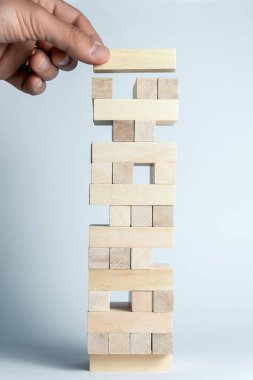 Erkek el, destek, takım çalışması ve iş geliştirme sembolü olarak, ahşap küpler kuleye bir küp koyar. Dikey çerçeve