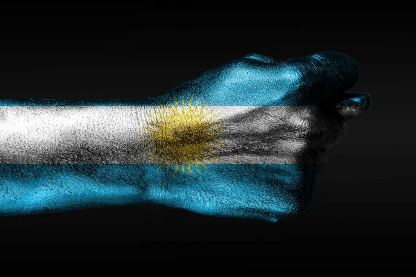 Uma mão com uma bandeira pintada da Argentina mostra um figo, um sinal de agressão, desacordo, uma disputa em um fundo escuro . — Fotografia de Stock