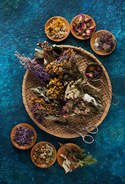 Dried healing herbs and flowers on a blue background, top view. Herbal Medicine