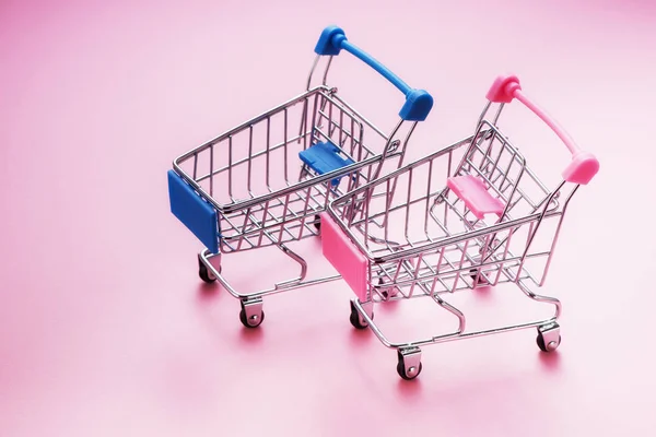 shopping carts on pink background with copy space