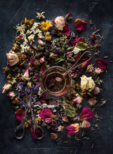 Floral herbal background with cup of herbal tea, top view flat lay