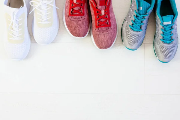 Multi-colored women's sports sneakers on the white floor. Selection