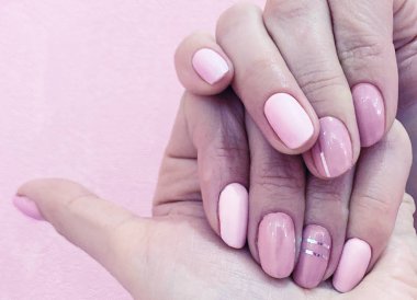 Kadınların elleri ile mükemmel çıplak manikür. Tırnak cilası doğal soluk pembe gölge var. -En fazla, pembe arka plan kapat