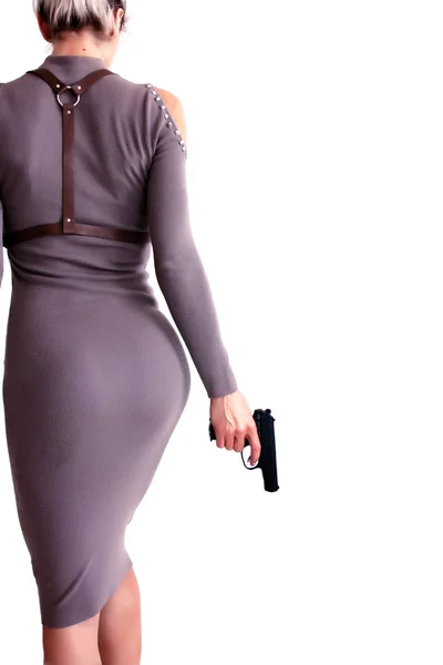 Hermosa mujer en un vestido sosteniendo un arma en su mano . — Foto de Stock