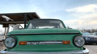 Çöplükte eski kırık arabalar. Terk edilmiş, bir ateş fıçıda yanar. Hızlı hareket. Zaman atlamalı.