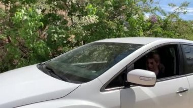 Güzel sarışın kadın beyaz bir büyük araba oturur ve telefonda iş yok.
