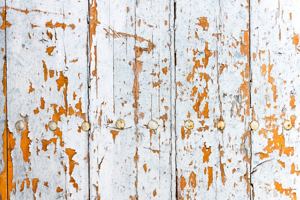 Weathered old worn wooden textured planks for wall or floor in white and brown with rusty nails as background