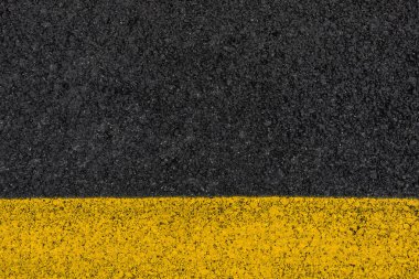 Yol grenli dokulu arka plan olarak sarı çizgili siyah sokak asfalt closeup