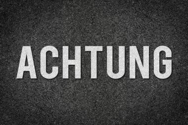 Asfalt beton sokak iletiyi şablon olarak beyaz Almanca yazılı dikkat