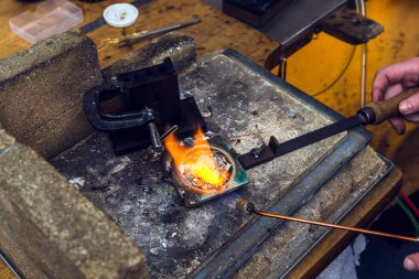 Pirinç metal bir meşale alev goldsmith yeri el sanatları metal işi gerçekleştirmek için çalışan, bir pota içinde ile erime