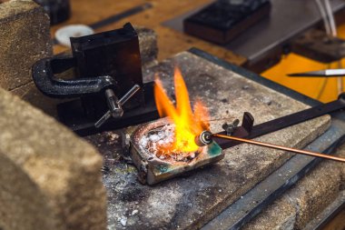 Pirinç metal bir meşale alev goldsmith yeri el sanatları metal işi gerçekleştirmek için çalışan, bir pota içinde ile erime