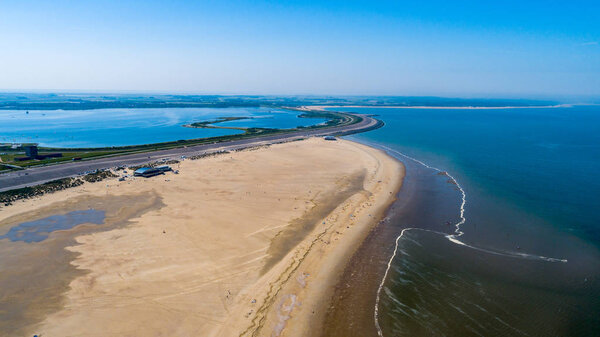 Aerial view taken by a drone at a beach and blue sea as seaside from zeeland in the Netherlands