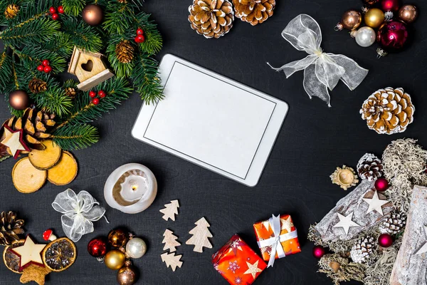 Noel dekorasyonu ve mutlu yeni yıl mesajı flatlay olarak siyah arka plan kopya alanı olan beyaz tablet