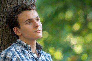 Genç adam parkta hayal kuruyor.