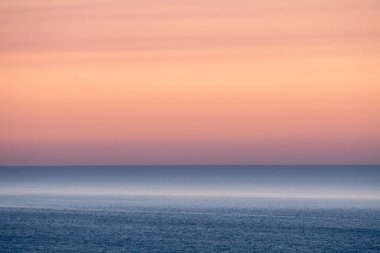 Pastel gölgelerle güzel bir gün batımı deniz manzarası, huzur ve sakin bir açık hava seyahati
