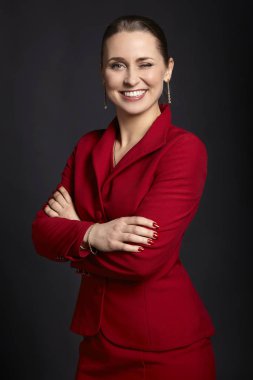 Stüdyo çekim beyaz bir gülümseme ve çapraz kolları ile genç kadının gözü siyah arka plan üzerinde yanıp.