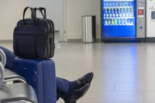 Ноги пассажира, сидящего рядом с чемоданами в зале ожидания — стоковое фото
