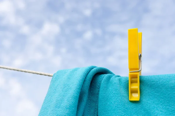 The linen clamped by a clothespeg dries on a rope — Stock Photo, Image