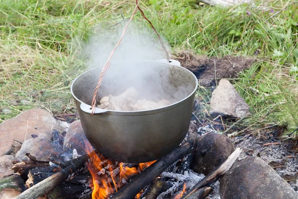燃える火の上に調理された食べ物を持つ観光ポット — ストック写真