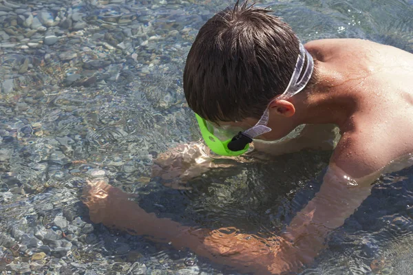 El adolescente en la máscara considera el fondo del mar en el día claro — Foto de Stock