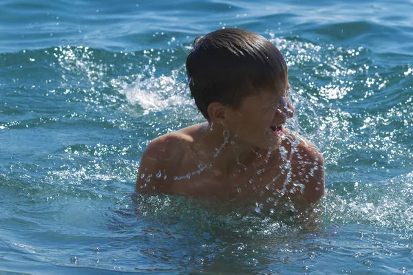 El adolescente nada en el mar azul en un día claro — Foto de Stock