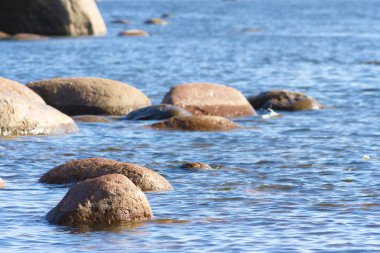Denizdeki kayalar. Bir yaz gününde mavi deniz dalgaları