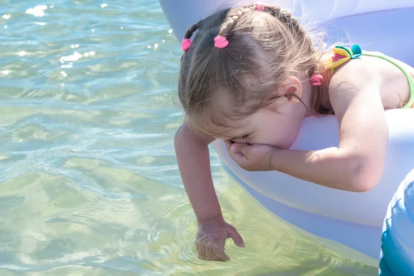 少女は夏の晴れた日に海のインフレータブルプールで遊んでいます — ストック写真