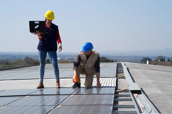 若いエンジニアの女の子と太陽光発電プラントをフィッティング高齢者熟練労働者 — ストック写真