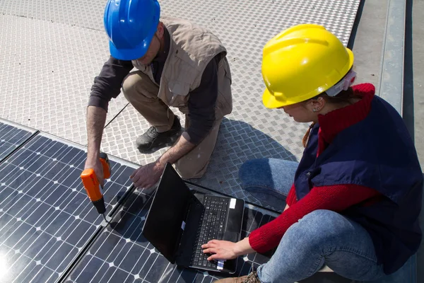 若いエンジニアの女の子と太陽光発電プラントをフィッティング高齢者熟練労働者 — ストック写真