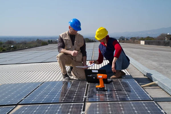 若いエンジニアの女の子と太陽光発電プラントをフィッティング高齢者熟練労働者 — ストック写真