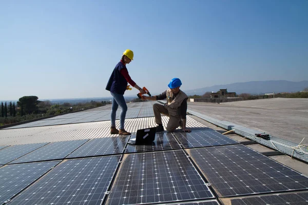 若いエンジニアの女の子と太陽光発電プラントをフィッティング高齢者熟練労働者 — ストック写真