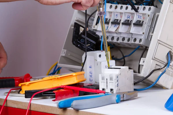 electrician fixing  electrical devices with different tools