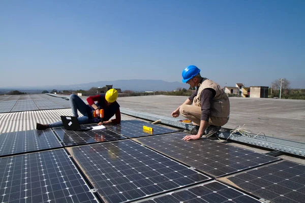 若いエンジニアの女の子と太陽光発電プラントをフィッティング高齢者熟練労働者 — ストック写真