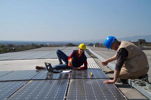 若いエンジニアの女の子と太陽光発電プラントをフィッティング高齢者熟練労働者 — ストック写真