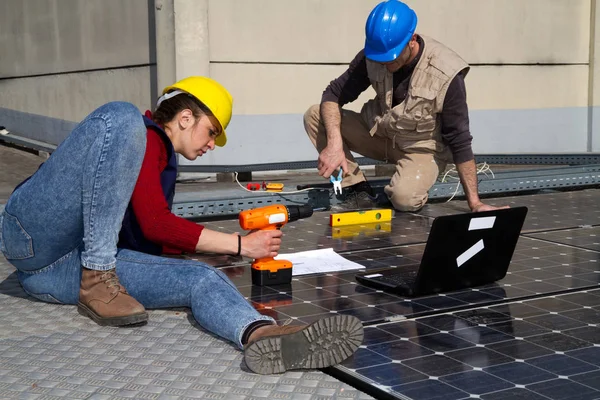 若いエンジニアの女の子と太陽光発電プラントをフィッティング高齢者熟練労働者 — ストック写真