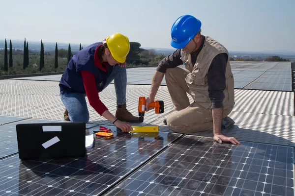 若いエンジニアの女の子と太陽光発電プラントをフィッティング高齢者熟練労働者 — ストック写真