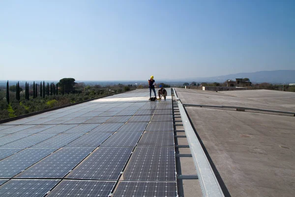 若いエンジニアの女の子と太陽光発電プラントをフィッティング高齢者熟練労働者 ストックフォト