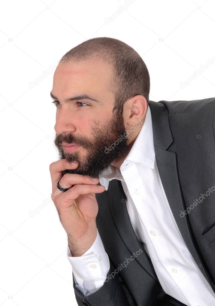 A young businessman sitting with his hand on his chin in a suit and