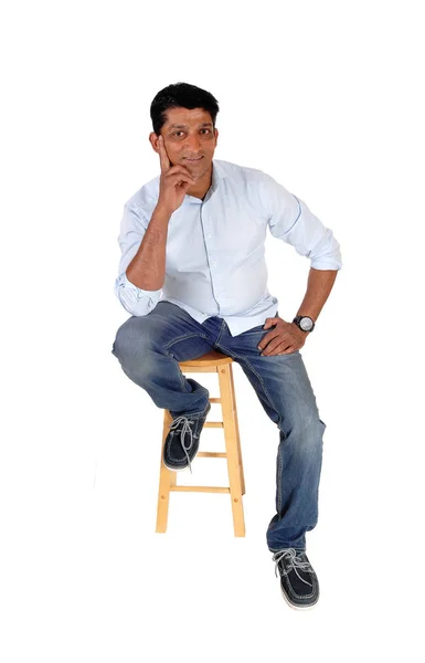 一个微笑的中年男子坐在椅子上牛仔裤和蓝色希尔山 — 图库照片