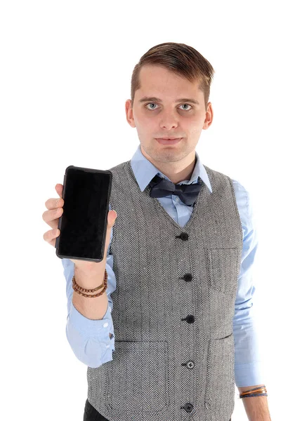 Young man holding up his cell phone in a vest — Stock Photo, Image