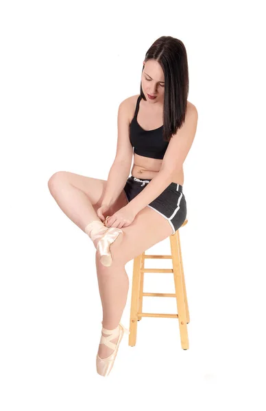 彼女のスポーツウェアの椅子の上に座っていると を入れてきれいな女性 — ストック写真