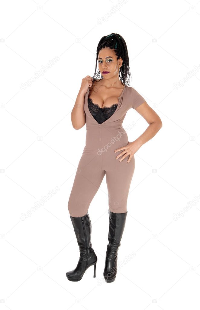A beautiful young woman standing in a beige color jumpsuit and bi