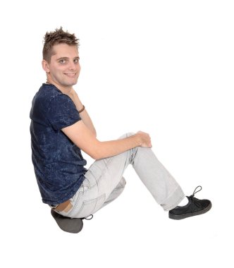 Işık gri Jeans katta oturan genç çok mutlu bir adam