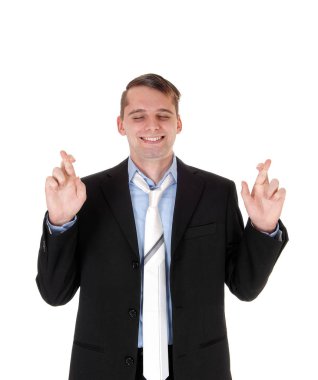 Genç bir iş ayakta takım elbiseli adam ve onun parmak crosse ile kravat