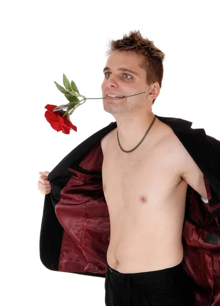 Hombre de pie sin camisa con una chaqueta abierta y una rosa en la boca — Foto de Stock